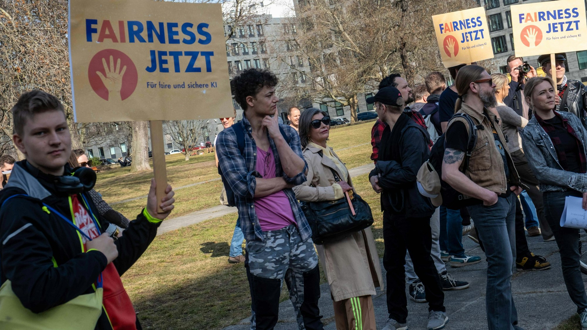 Aktivisten demonstrieren mit Schildern für Fairness und KI