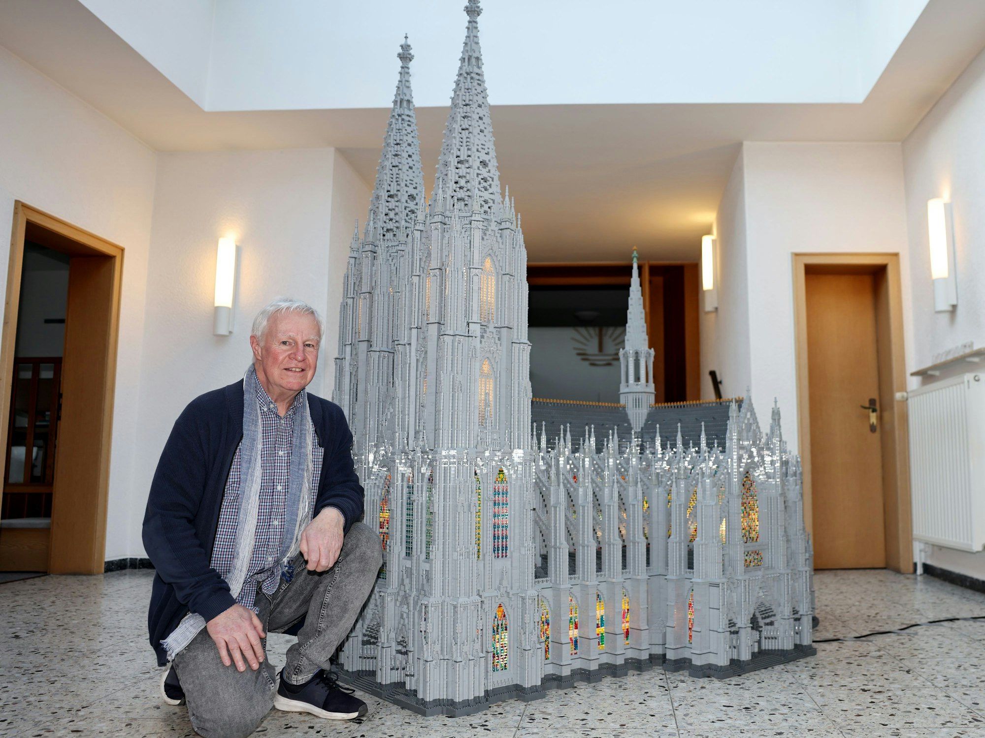 Volker Pardon steht an einem Kölner Dom aus Lego-Steinen.