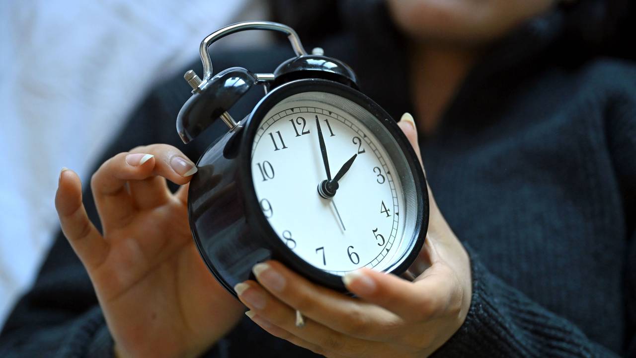 Eine Frau hält einen Wecker in der Hand. Am 29. März 2026 hat die Sommerzeit begonnen.