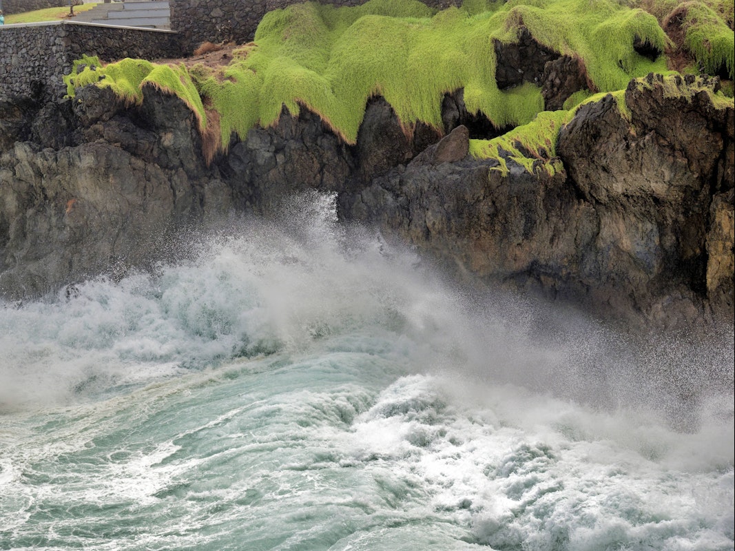 Hohe Wellen schlagen an die Felsen von Porto Moniz auf Madeira.