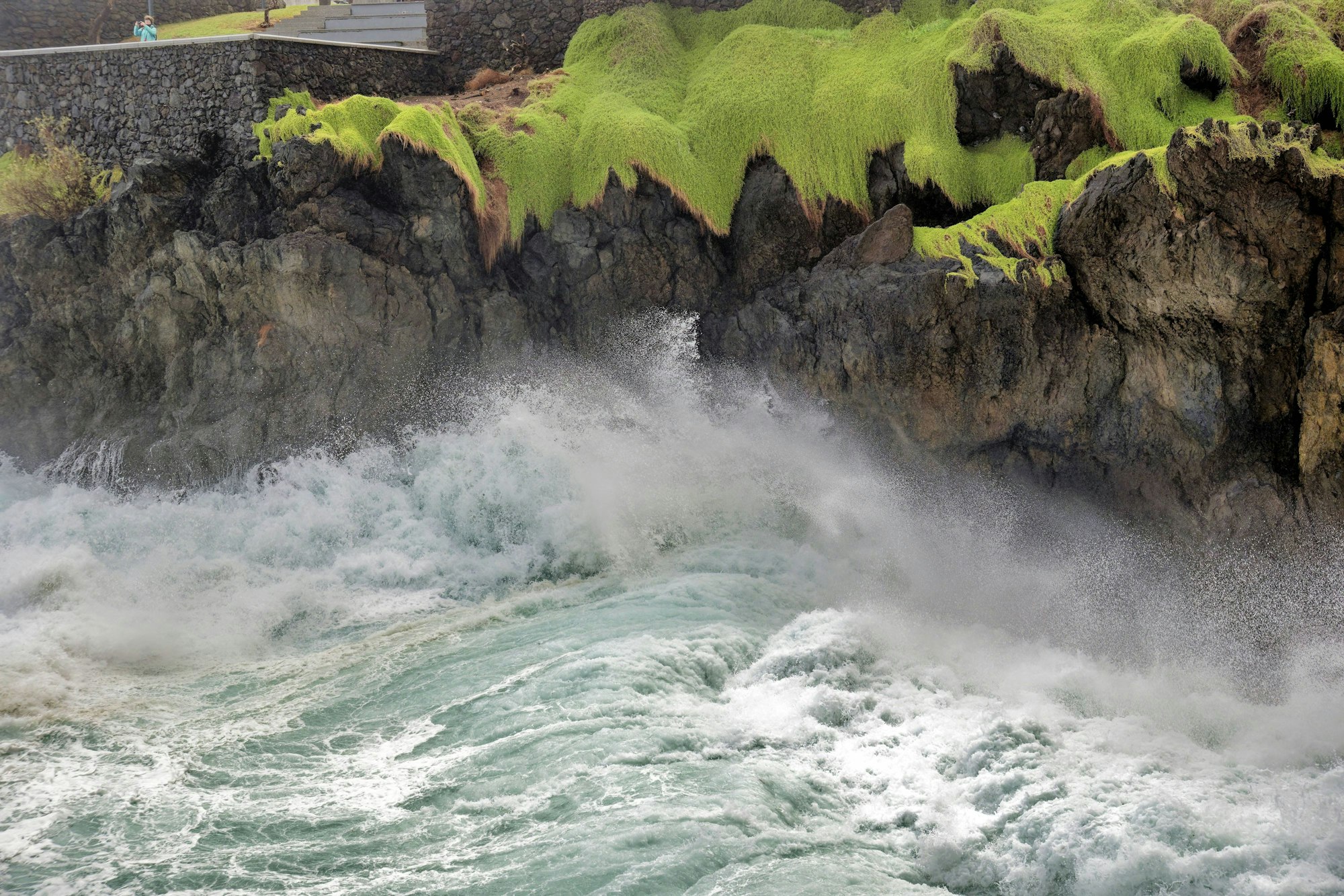 Hohe Wellen schlagen an die Felsen von Porto Moniz auf Madeira.