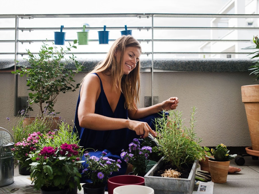 Eine Frau bepflanzt ihren Balkon