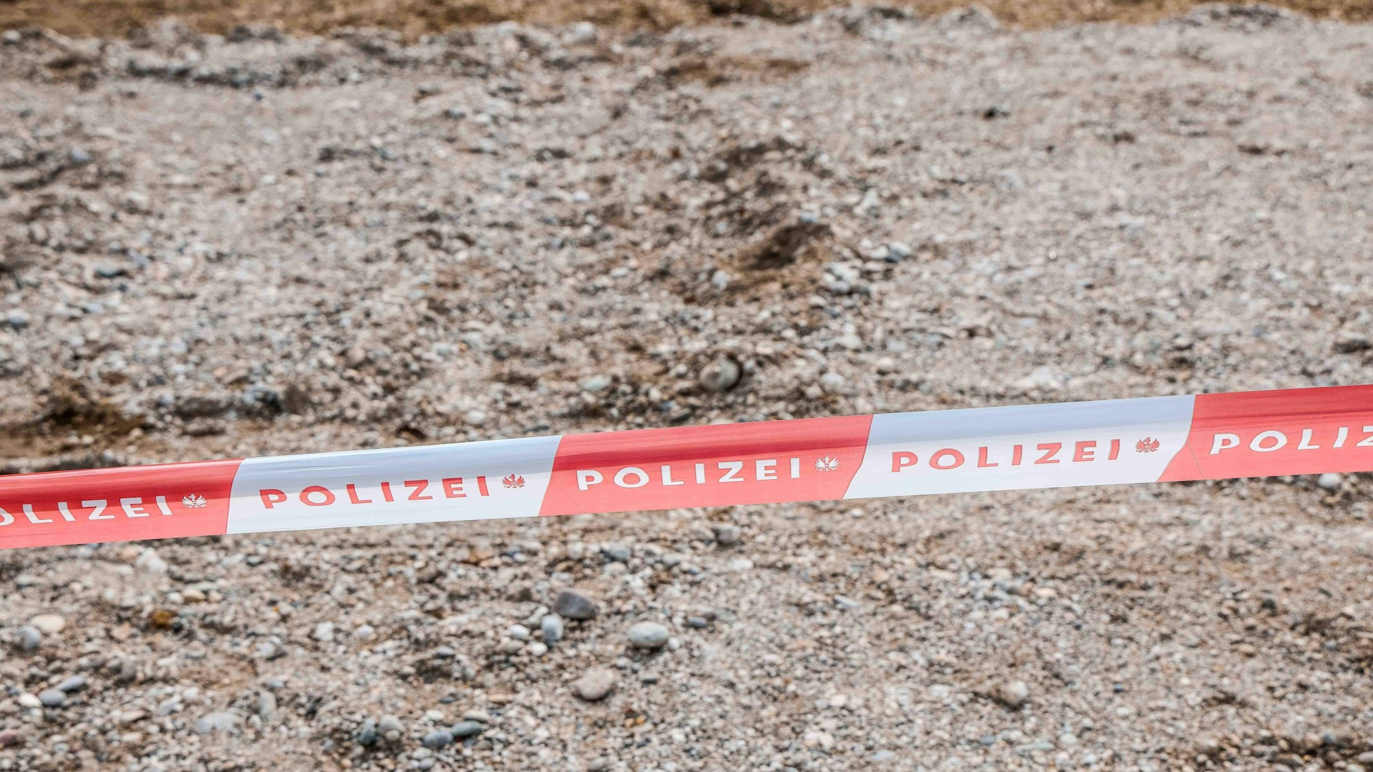 Polizei Absperrband auf steinigem Boden