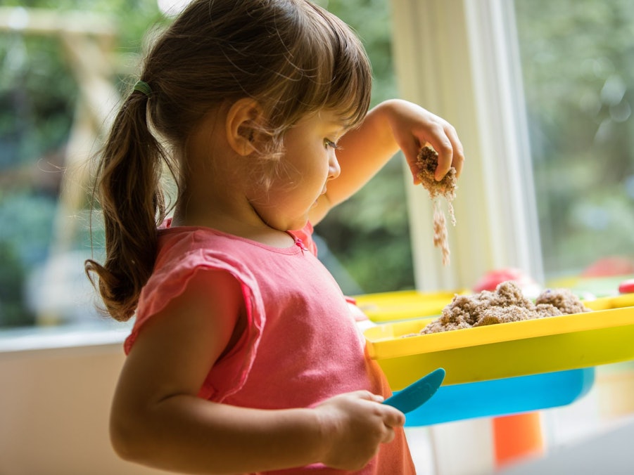 Ein Mädchen soielt mit Knetsand