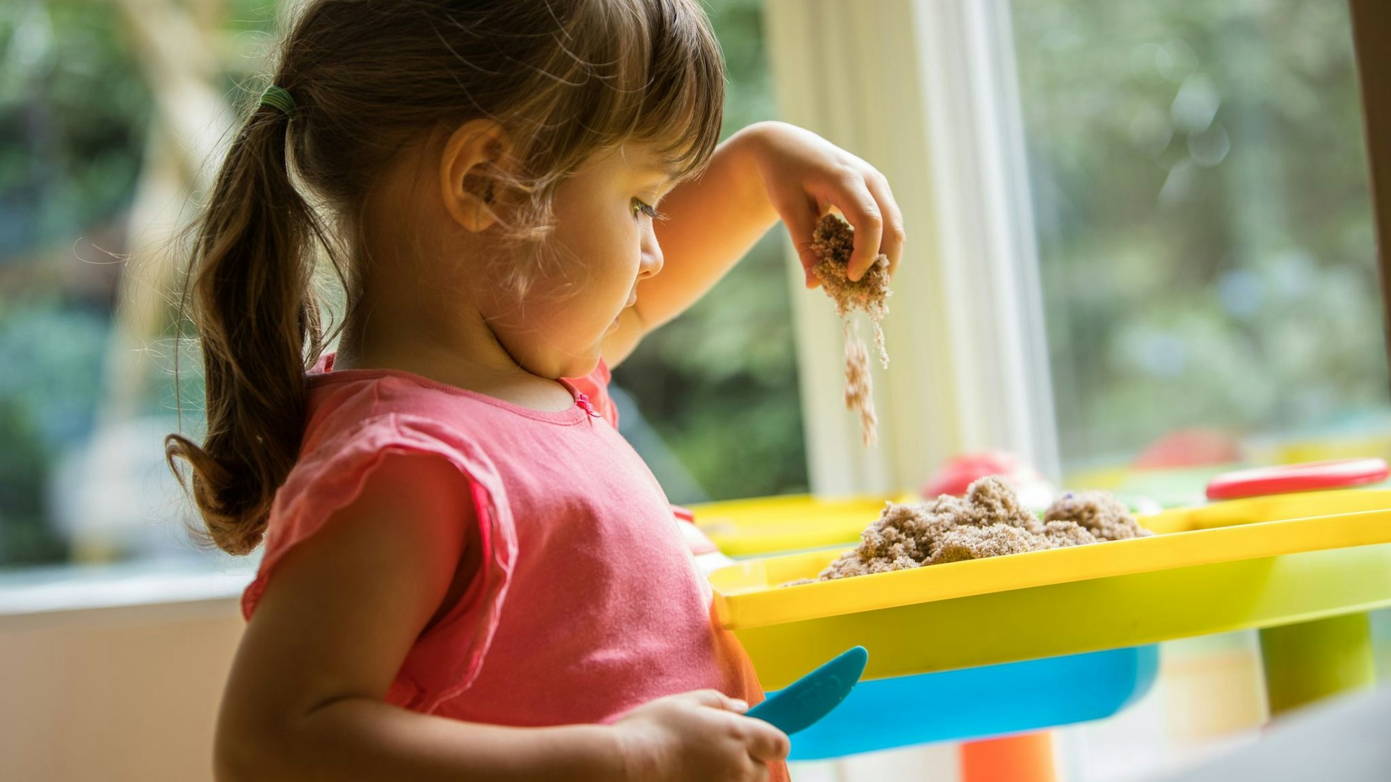 Ein Mädchen soielt mit Knetsand