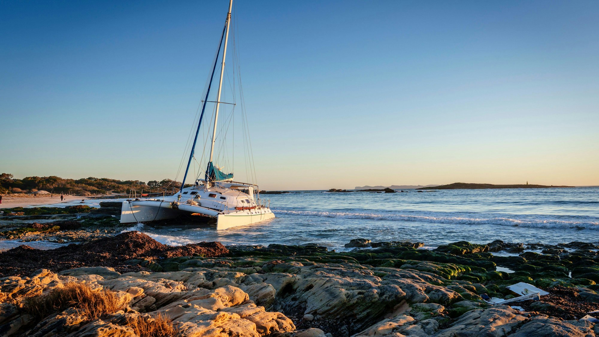 Katamaran an felsiger Küste gestrandet