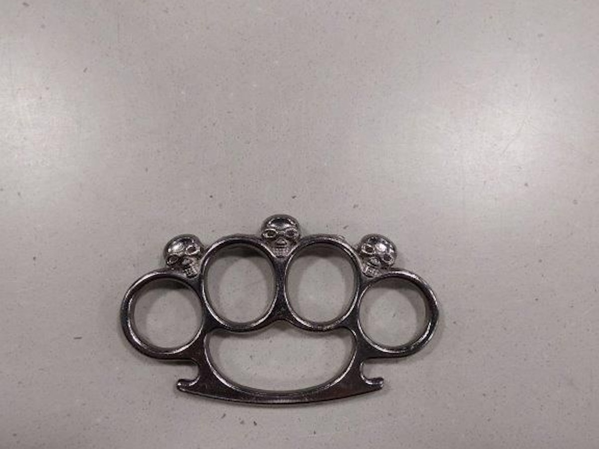 Ein metallischer Schlagring liegt auf einer Oberfläche.