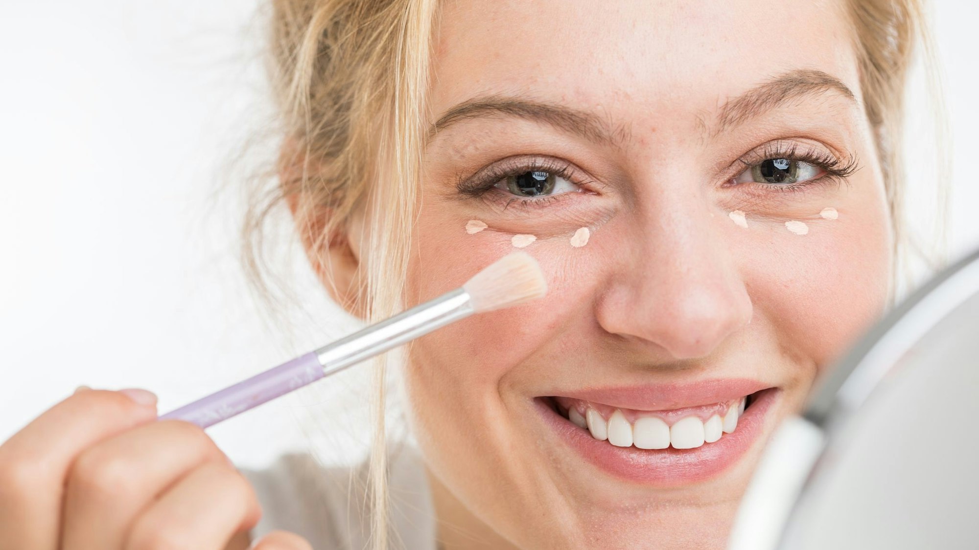 Eine Faru trägt Concealer auf