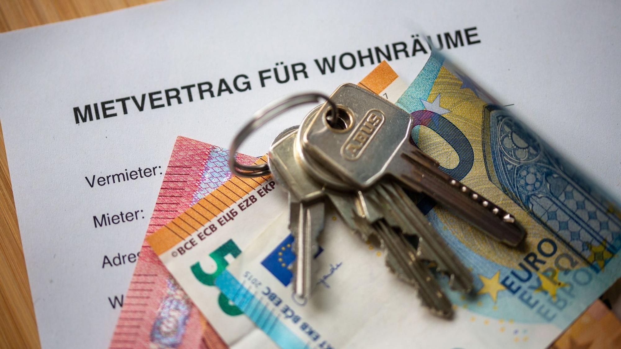 Mietvertrag, Geldscheine und Hausschlüssel auf einem Tisch