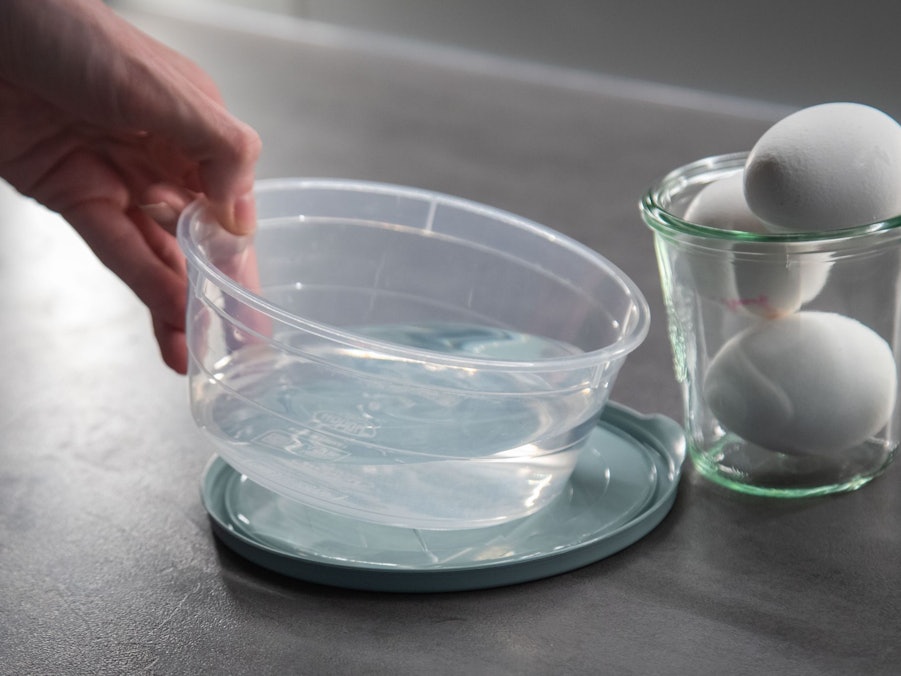 Eier liegen neben einer Schale Wasser