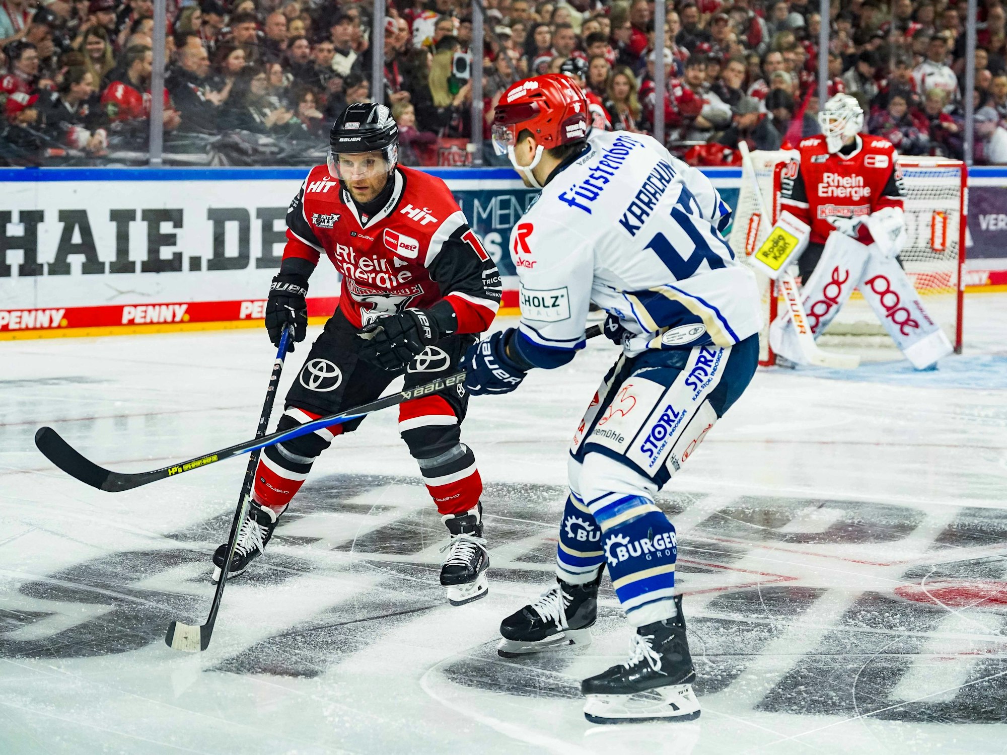 Kölns Frederik Storm gegen Schwenningens Alexander Karachun auf dem Eis.