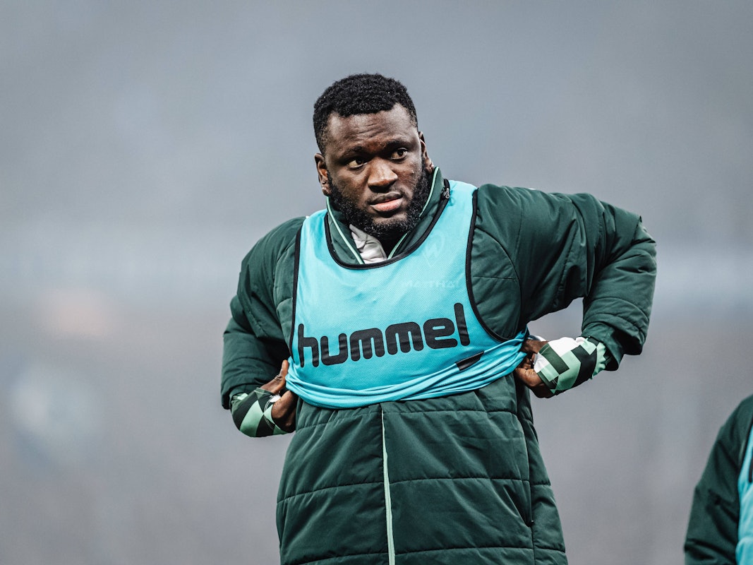 Victor Boniface zieht sich ein Leibchen über die Jacke.