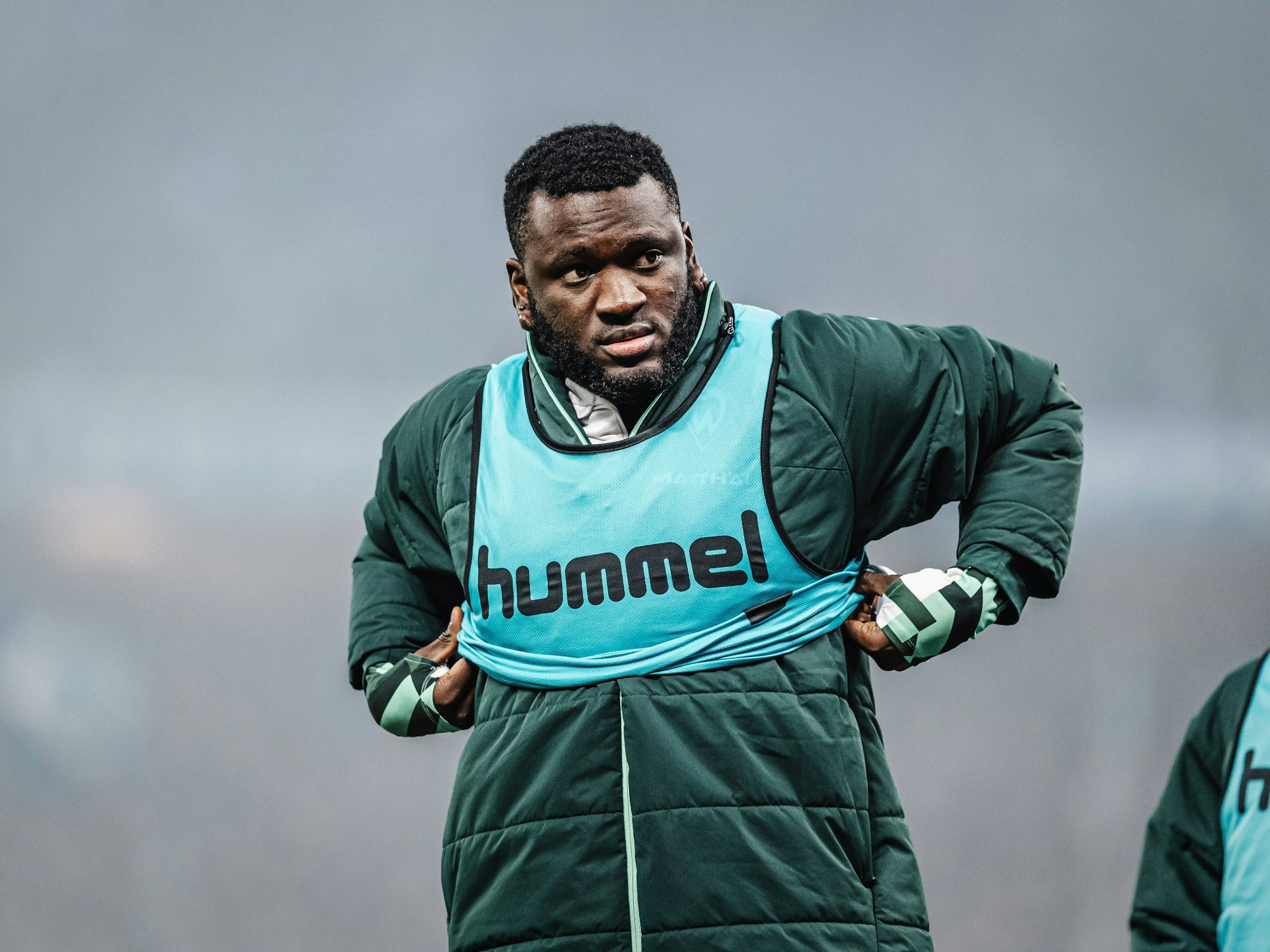 Victor Boniface zieht sich ein Leibchen über die Jacke.