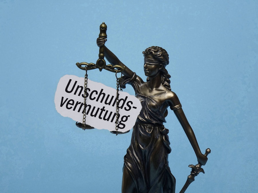 Justitia und Schriftzug „Unschuldsvermutung“