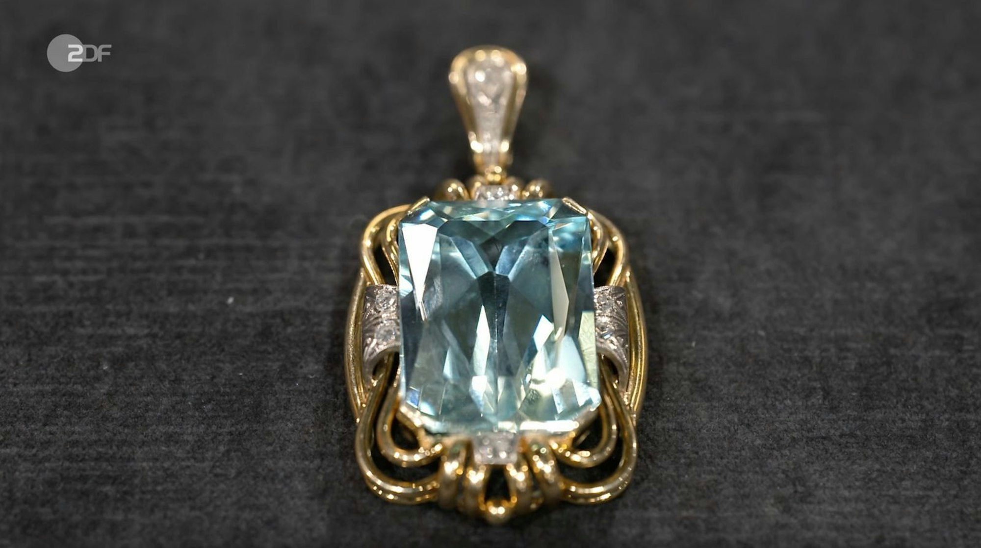 „Meine Oma war immer knacke-braun und der Anhänger sah auf der gebräunten Haut toll aus“, erzählte Verkäuferin Andrea von ihren Erinnerungen. „Ganz wunderbar und schick“, konnte sich auch die Expertin das Bild der Großmutter gut vorstellen. Der Aquamarin im Scherenschliff brachte zudem „stattliche 39 Karat“ auf die Waage. (Bild: ZDF)