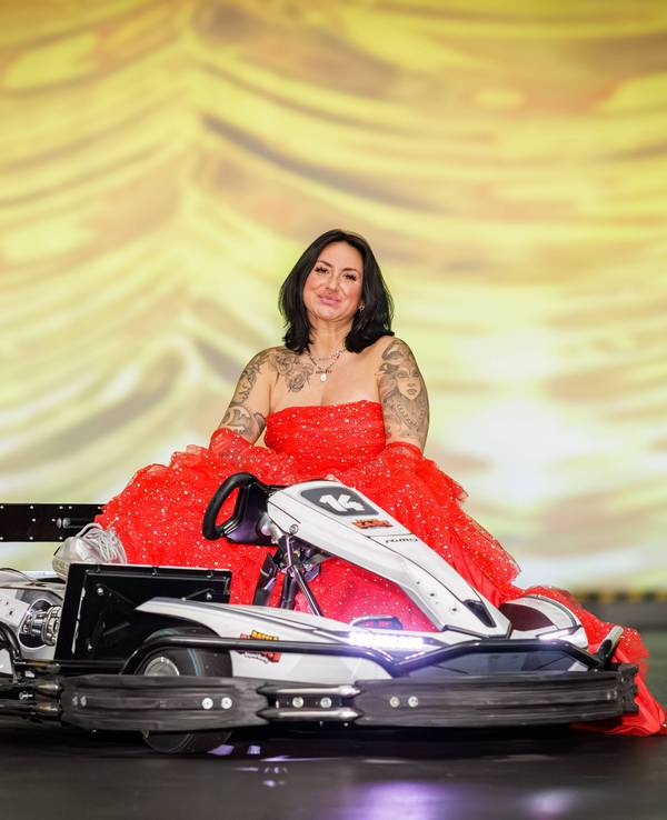 Nicki Pistola sitzt Battle-Kart-Arena in Neuss neben einem Kart.