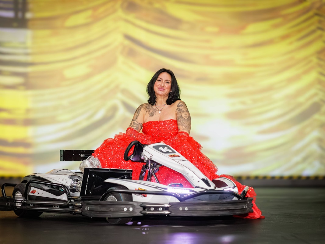 Nicki Pistola sitzt Battle-Kart-Arena in Neuss neben einem Kart.