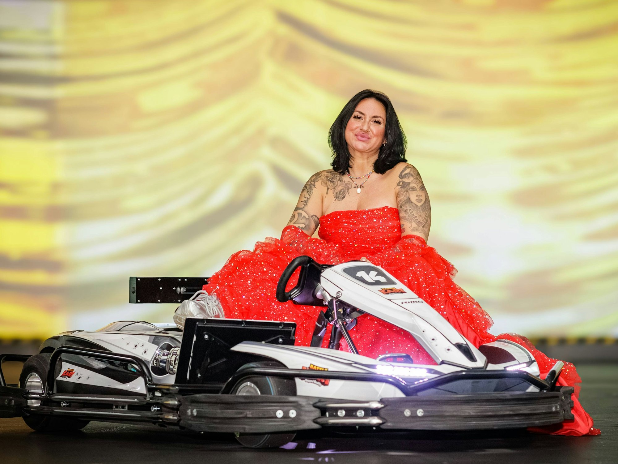 Nicki Pistola sitzt Battle-Kart-Arena in Neuss neben einem Kart.