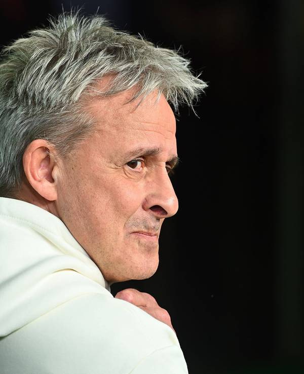 Pierre Littbarski schaut im Hoodie über seine rechte Schulter.