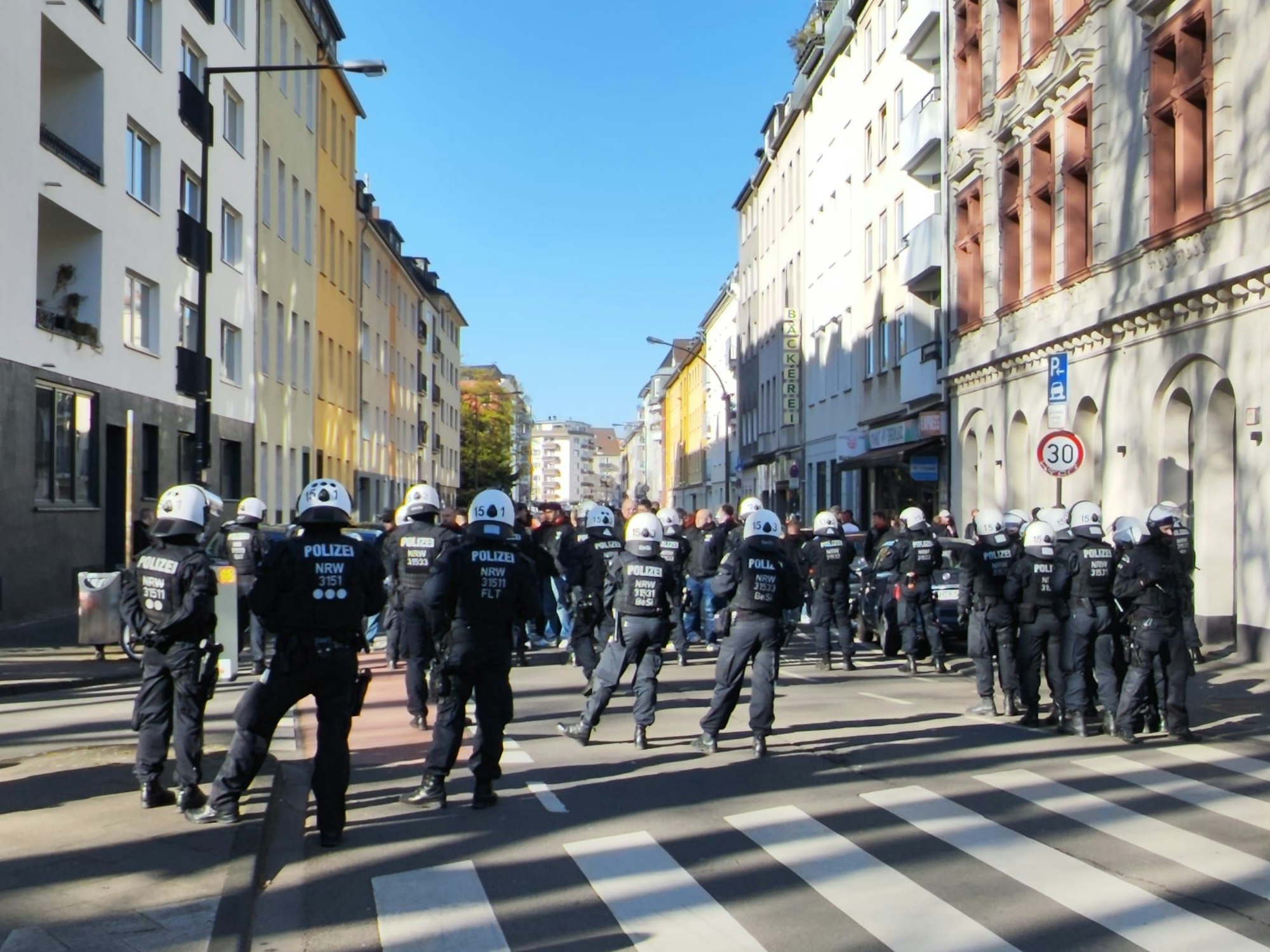 Bei einem Polizeieinsatz in der Kölner Südstadt versperrt am 1. April 2026 eine Einsatzhundertschaft den Weg.