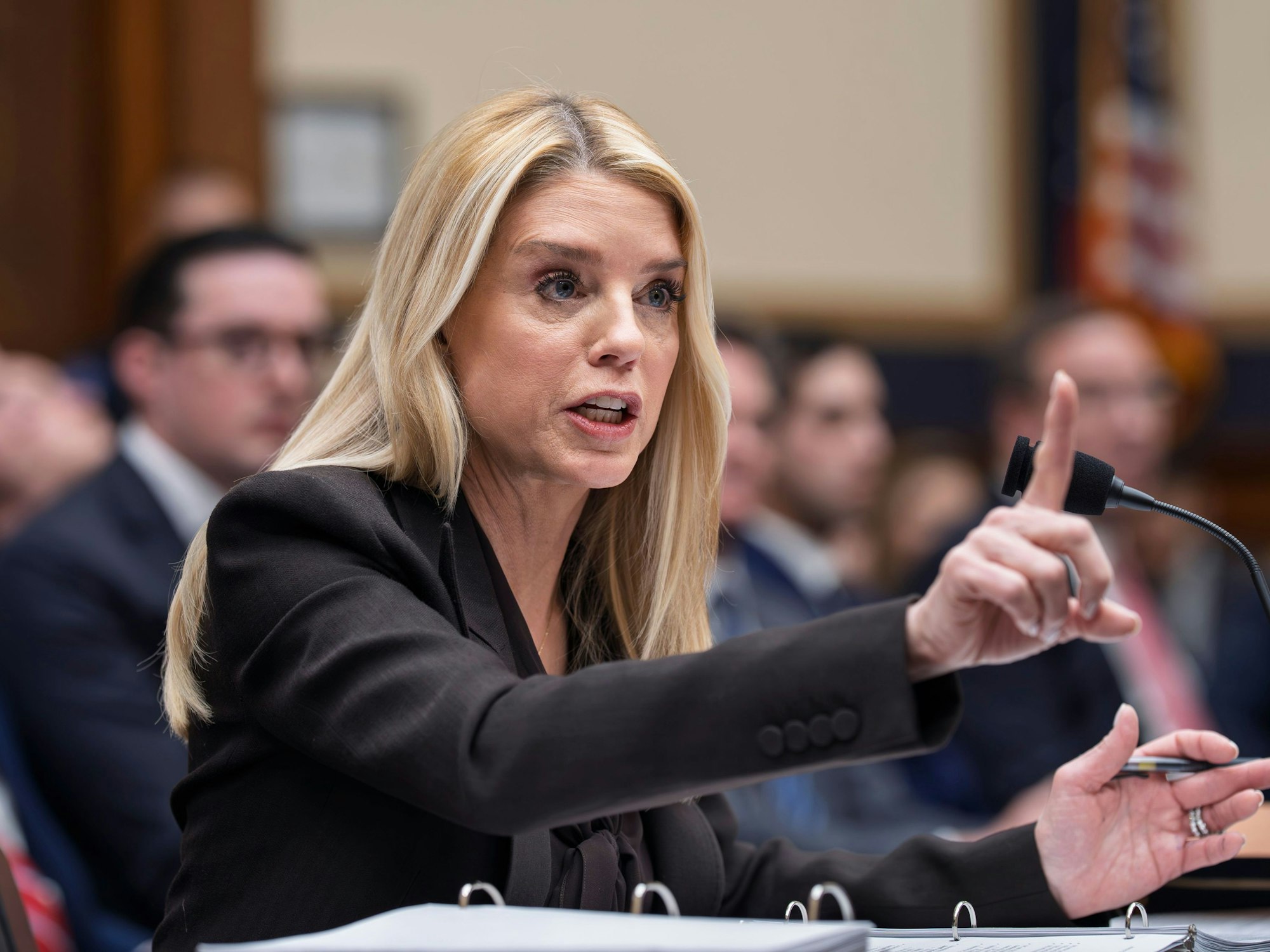 US-Justizministerin Pam Bondi gestikuliert vor einem Mikrofon.