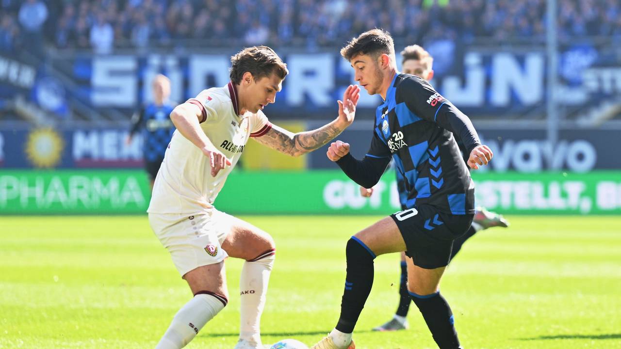 Stefano Marino (r, SC Paderborn 07) versucht an Julian Pauli (l, Dynamo Dresden) vorbeizukommen.