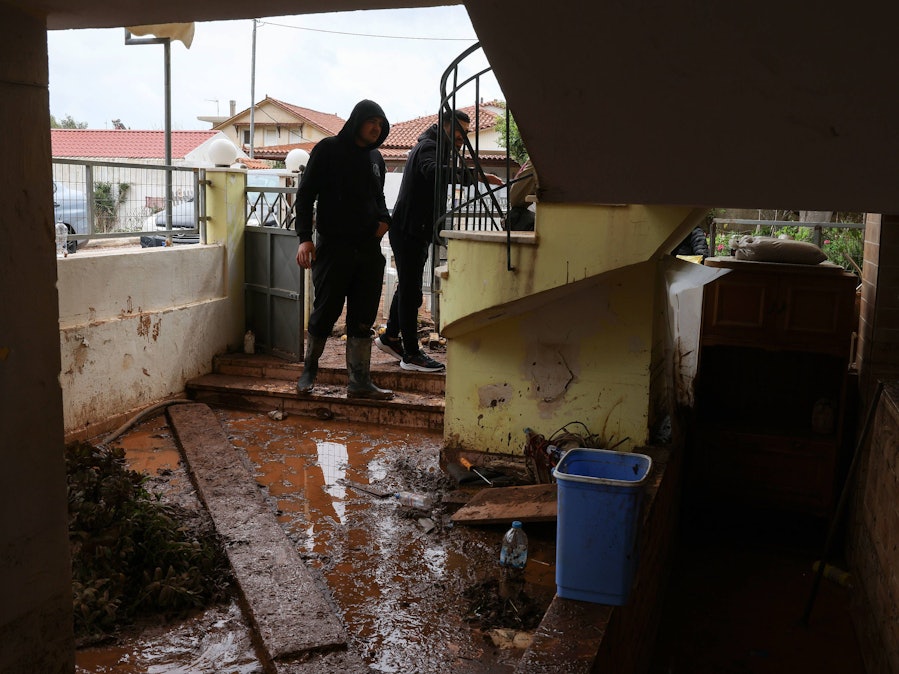 Männer in schlammiger Umgebung nach Überschwemmung