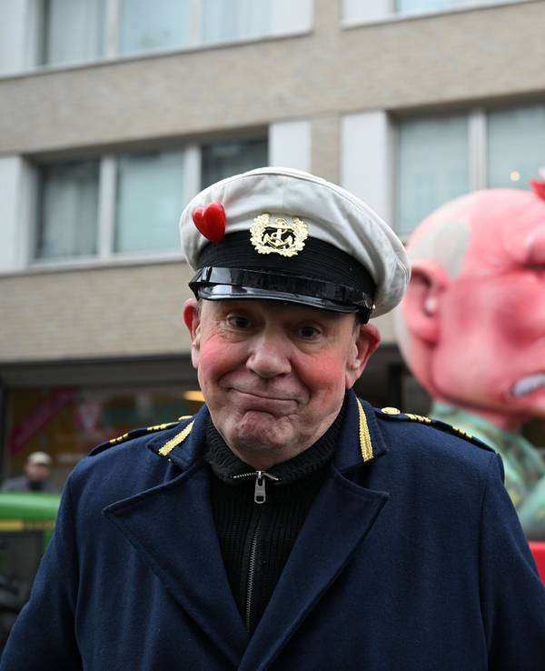 Jacques Tilly steht vor dem Mottowagen auf dem Putin die Düsseldorfer Karnevalsfigur Hoppeditz aufspießt.