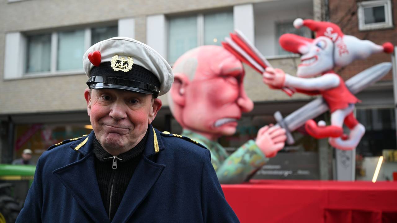 Jacques Tilly steht vor dem Mottowagen auf dem Putin die Düsseldorfer Karnevalsfigur Hoppeditz aufspießt.
