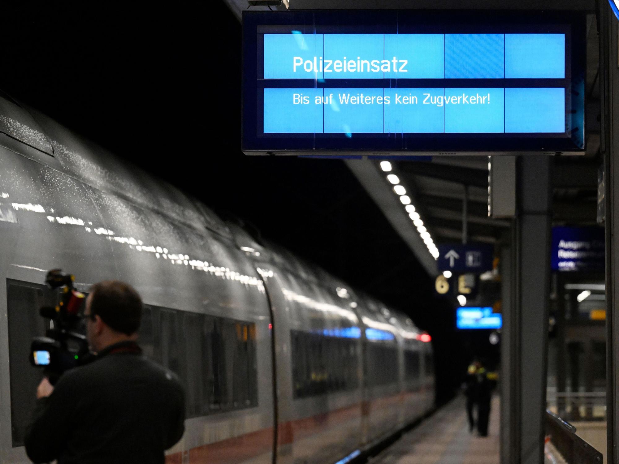 „Polizeieinsatz“ wird auf einem Display an einem Bahnsteig im Bahnhof Siegburg angezeigt, auf dem ein ICE der Deutschen Bahn steht. Ein Mann hat laut Bundespolizei in einem ICE in Nordrhein-Westfalen mit einem Anschlag gedroht und mehrere Menschen leicht verletzt.