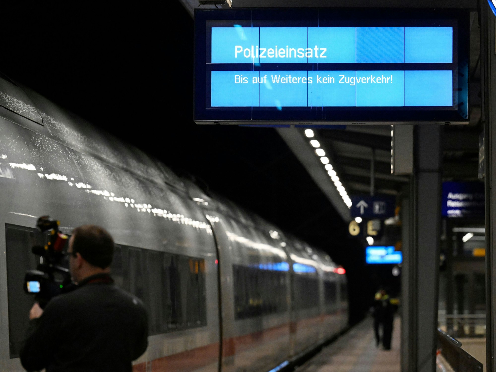 „Polizeieinsatz“ wird auf einem Display an einem Bahnsteig im Bahnhof Siegburg angezeigt, auf dem ein ICE der Deutschen Bahn steht. Ein Mann hat laut Bundespolizei in einem ICE in Nordrhein-Westfalen mit einem Anschlag gedroht und mehrere Menschen leicht verletzt.
