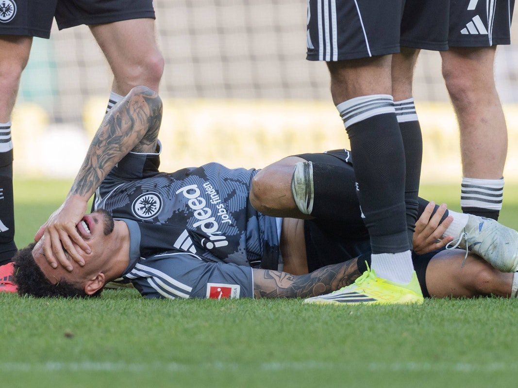 Nnamdi Collings liegt mit Schmerzen auf dem Rasen und hält eine Hand über sein Gesicht.