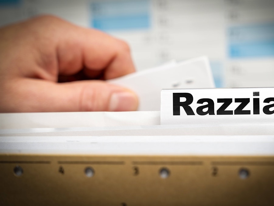 Hand am Karteikasten mit Aufschrift Razzia