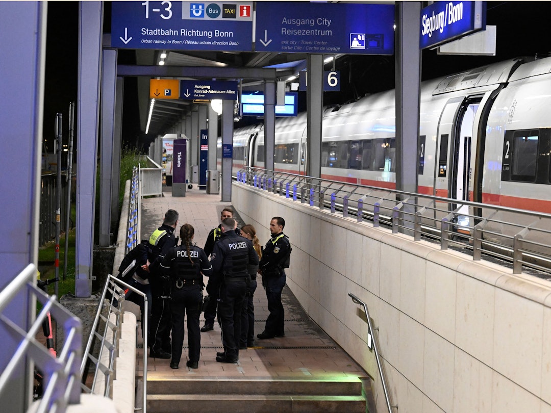 Polizisten stehen auf einem Bahnsteig im Bahnhof Siegburg, auf dem ein ICE der Deutschen Bahn steht. Ein Mann hat laut Bundespolizei in einem ICE in Nordrhein-Westfalen mit einem Anschlag gedroht und mehrere Menschen leicht verletzt.
