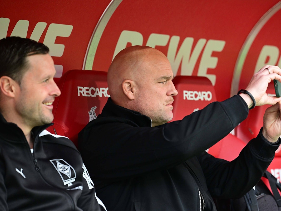 Auf der Ersatzbank macht Rouven Schröder ein Foto mit dem Handy im Stadion.