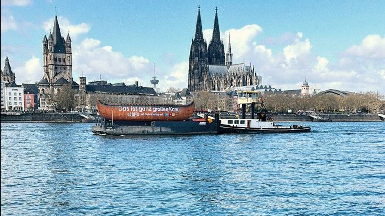 Das „Kanu des Manitu“ schippert über den Rhein bei Köln.