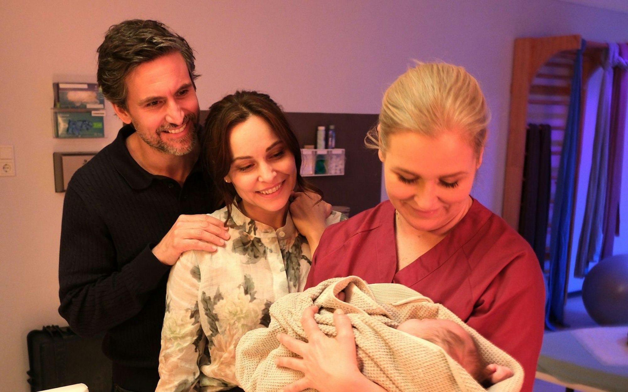 Jan (Tom Beck) und Katina Wolff (Mina Tander, Mitte) zeigen sich sichtlich gerührt, als Lena Lorenz (Judith Hoersch) ihnen ihre neugeborene Adoptivtochter präsentiert. (Bild: ZDF/Jacqueline Krause-Burberg)