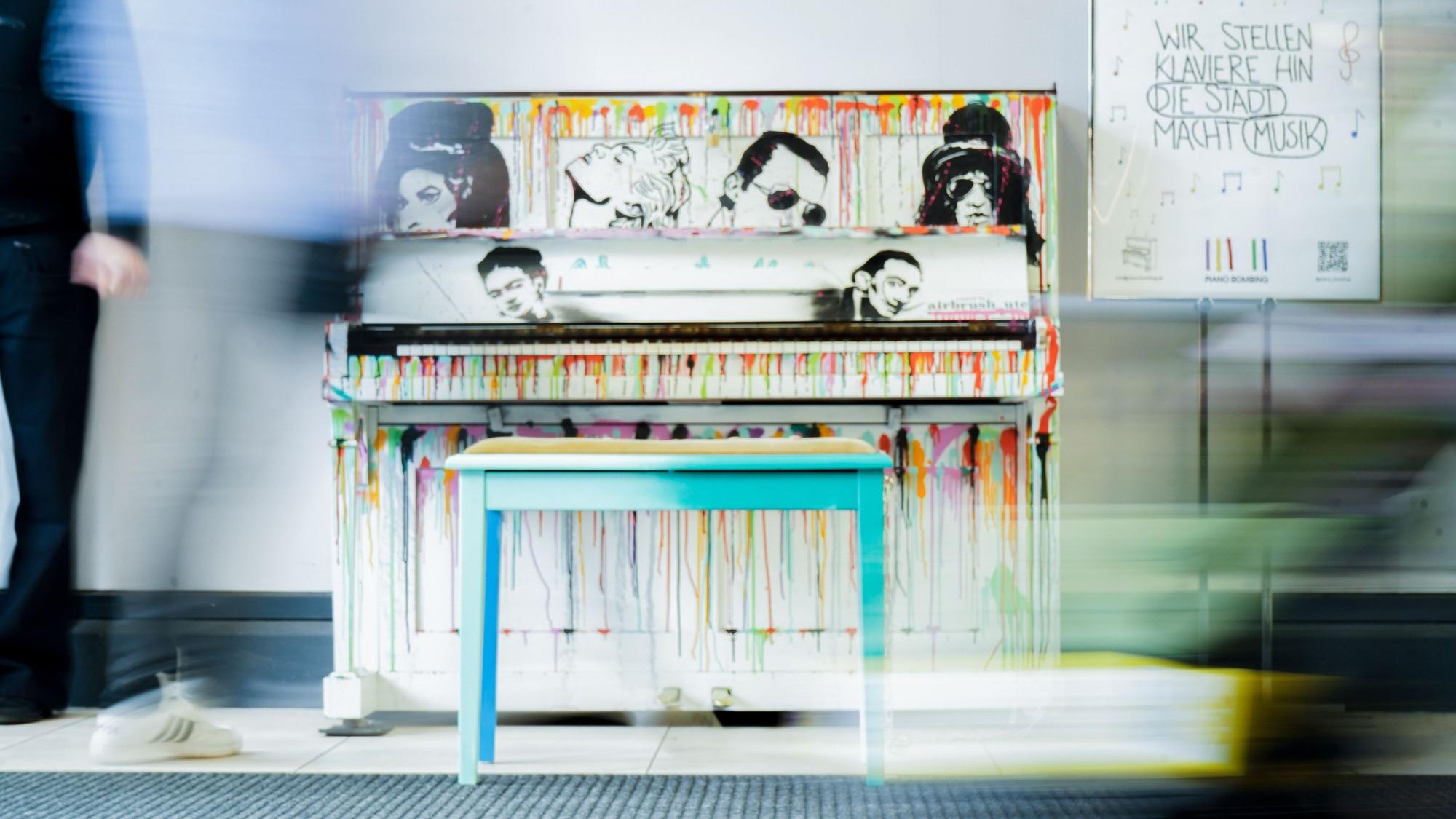 An einem Klavier sind die Portraits unter anderem von Freddie Mercury, Amy Winehouse und Madonna gemalt.