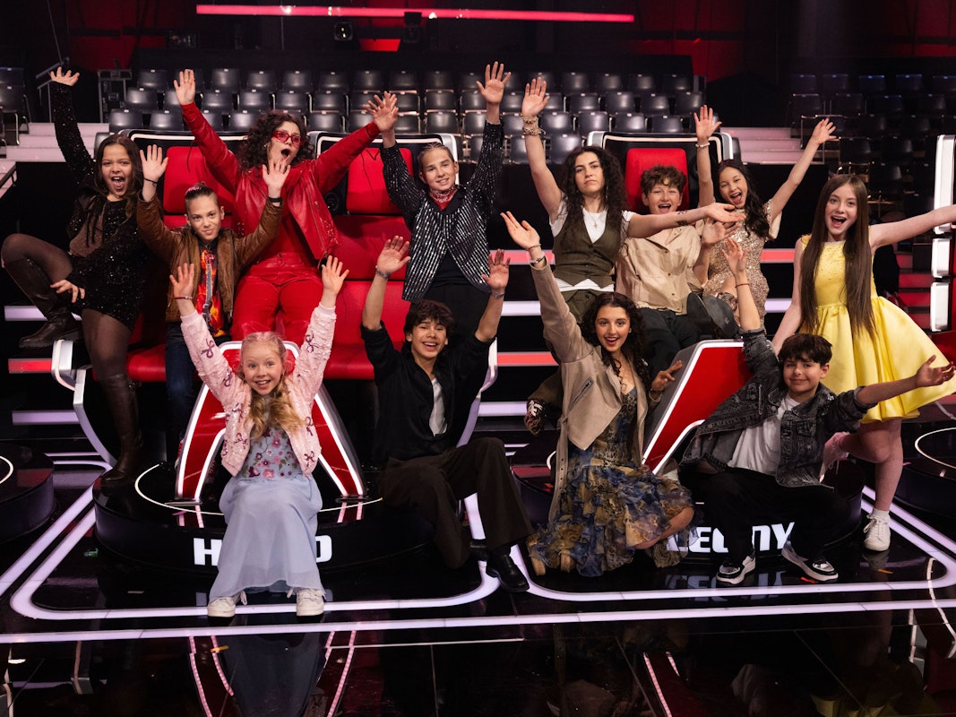 Die zwölf Final-Teilnehmer und Teilnehmerinnen von „The Voice Kids“ sitzen im Fernsehstudio auf den Jury-Stühlen: Danaya (hinten, l-r), Levy, Lionella, Illia, Marie, Max, Angelina und Katelyn, sowie (vorn, l-r) Hedi , Fabio, Susey und Renat.