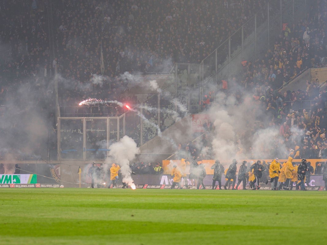 Dynamo-Fans werfen Pyrotechnik in den Hertha-Gästeblock.