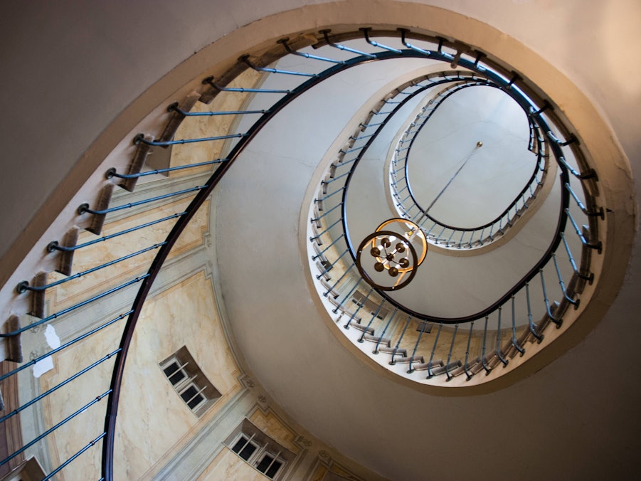 Wendeltreppe mit Leuchter und Fenstern