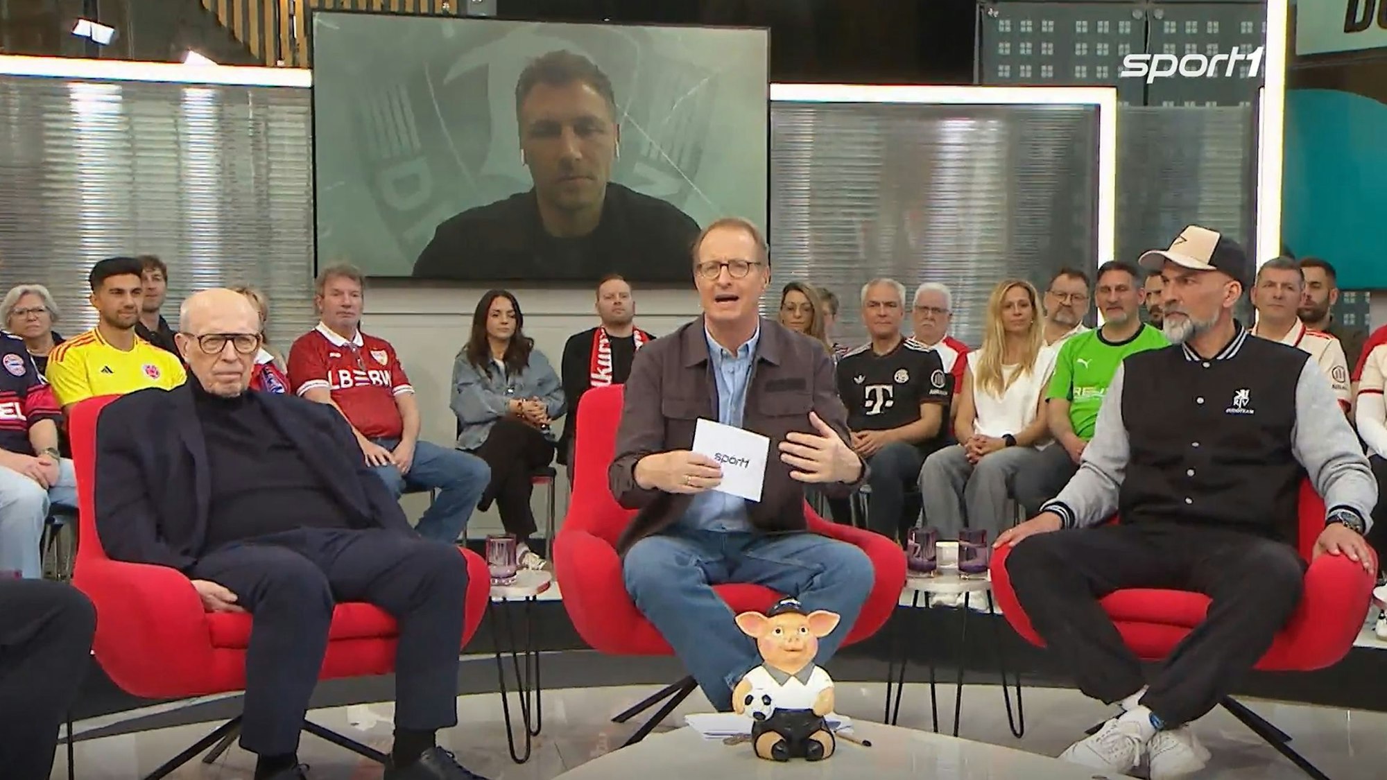 Sören Gonther ist im Doppelpass auf einem Bildschirm zu sehen.