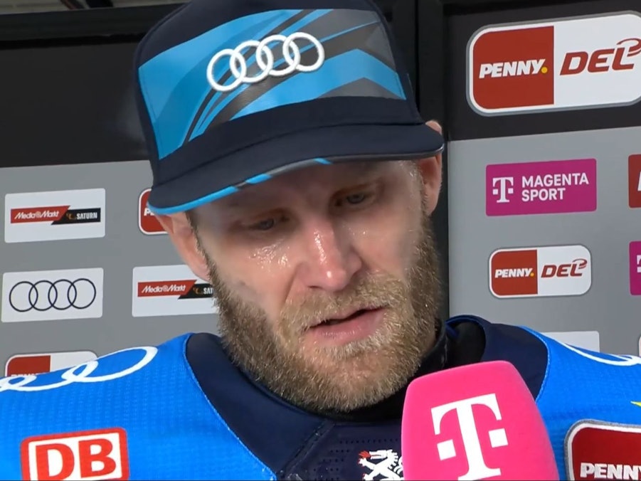 Daniel Pietta spricht in ein Mikrofon mit Telekom-Logo.