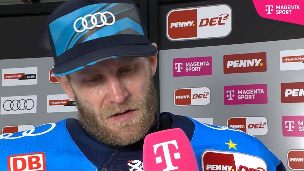 Daniel Pietta spricht in ein Mikrofon mit Telekom-Logo.