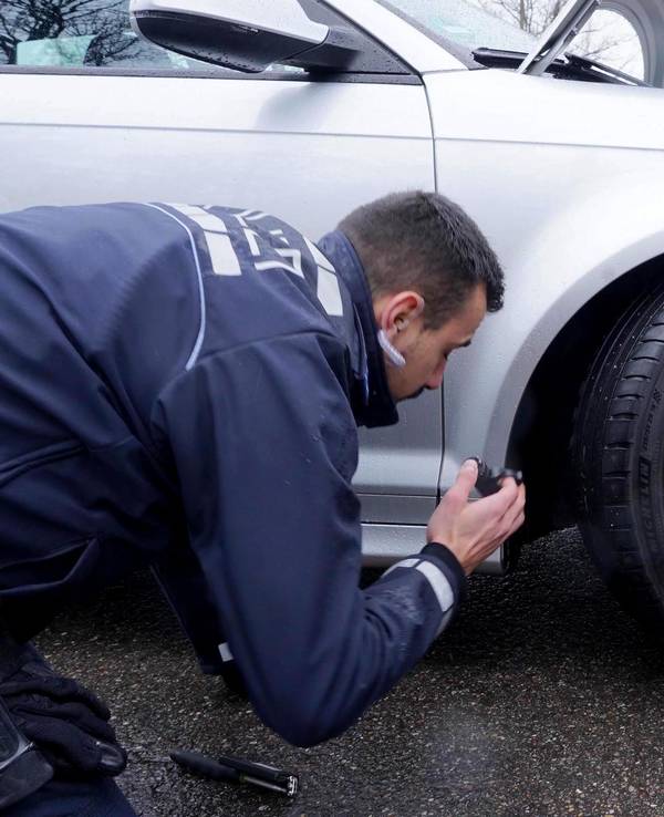Ein Polizist kontrolliert ein Fahrzeug beim „Car-Freitag“ Tuning-Treffen auf einem Parkplatz beim Fernsehturm in Stuttgart.