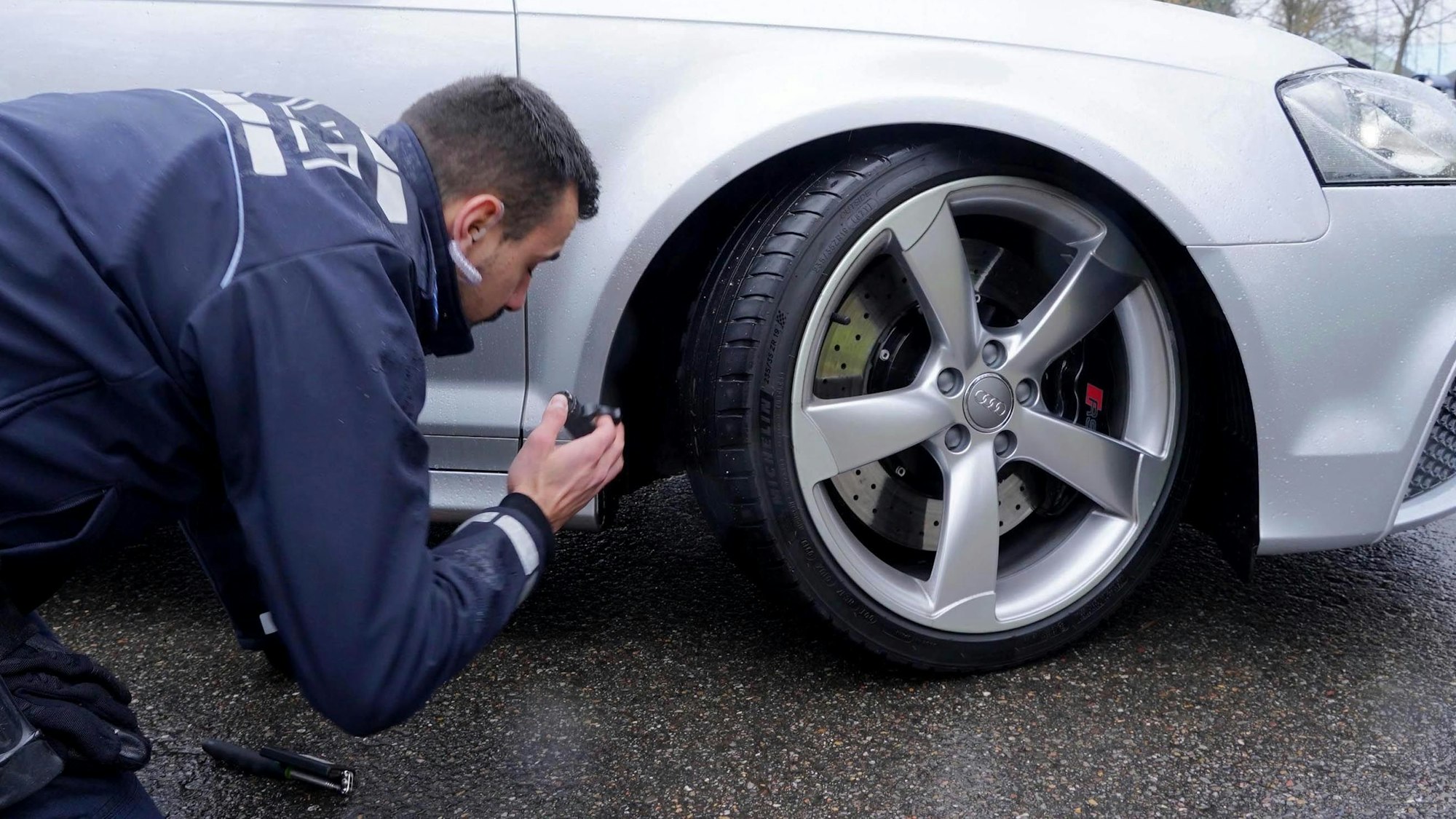 Ein Polizist kontrolliert ein Fahrzeug beim „Car-Freitag“ Tuning-Treffen auf einem Parkplatz beim Fernsehturm in Stuttgart.