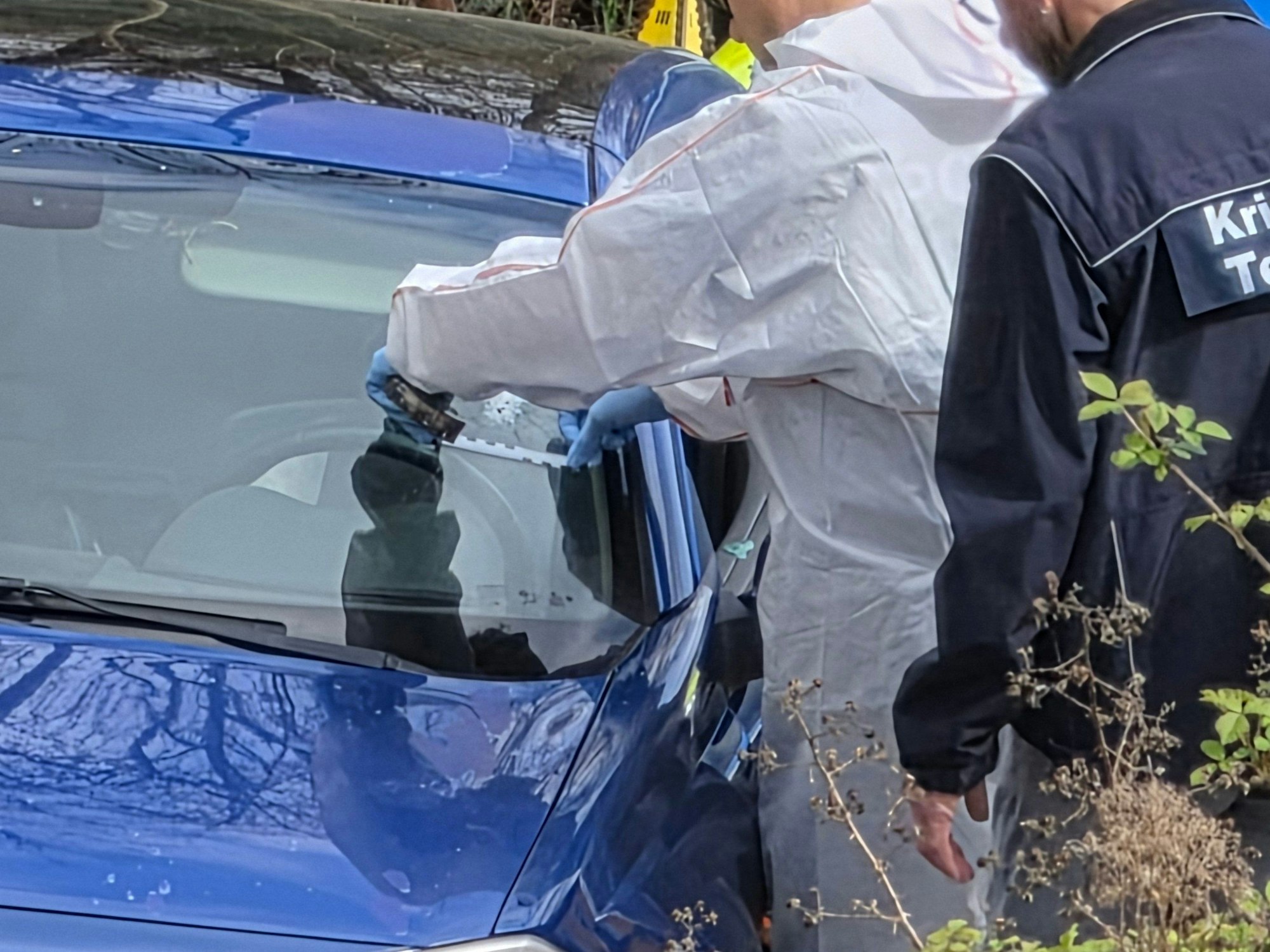 Kriminaltechniker arbeiten am Einsatzort. Bei einer Verfolgungsfahrt in Saarbrücken ist ein Mann durch Polizeischüsse verletzt worden und danach gestorben. Ein Schuss ging offensichtlich direkt durch die Windschutzscheibe.