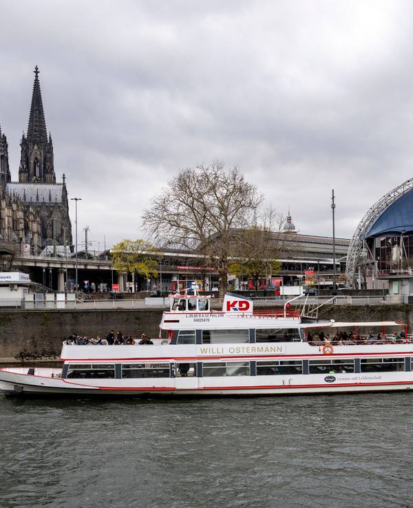 Das Kölner Rheinufer mit Blick das Schiff „Willi Ostermann“, das vor der Kölner Altstadt und dem Kölner Dom am Ufer angelegt hat.