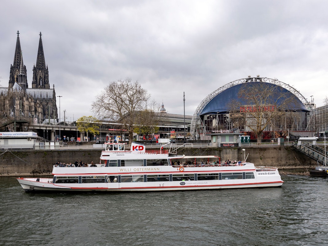 Das Kölner Rheinufer mit Blick das Schiff „Willi Ostermann“, das vor der Kölner Altstadt und dem Kölner Dom am Ufer angelegt hat.