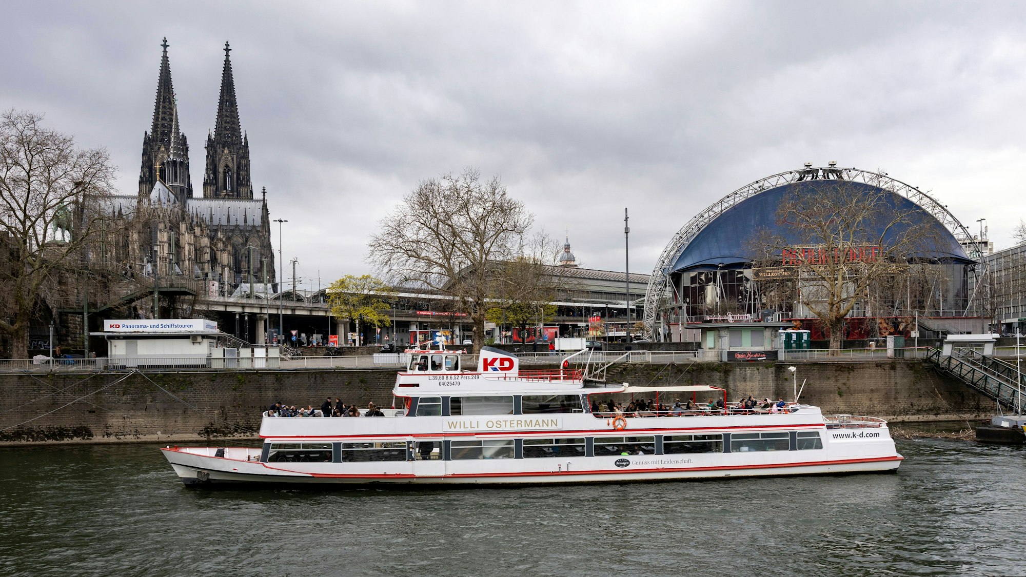 Das Kölner Rheinufer mit Blick das Schiff „Willi Ostermann“, das vor der Kölner Altstadt und dem Kölner Dom am Ufer angelegt hat.